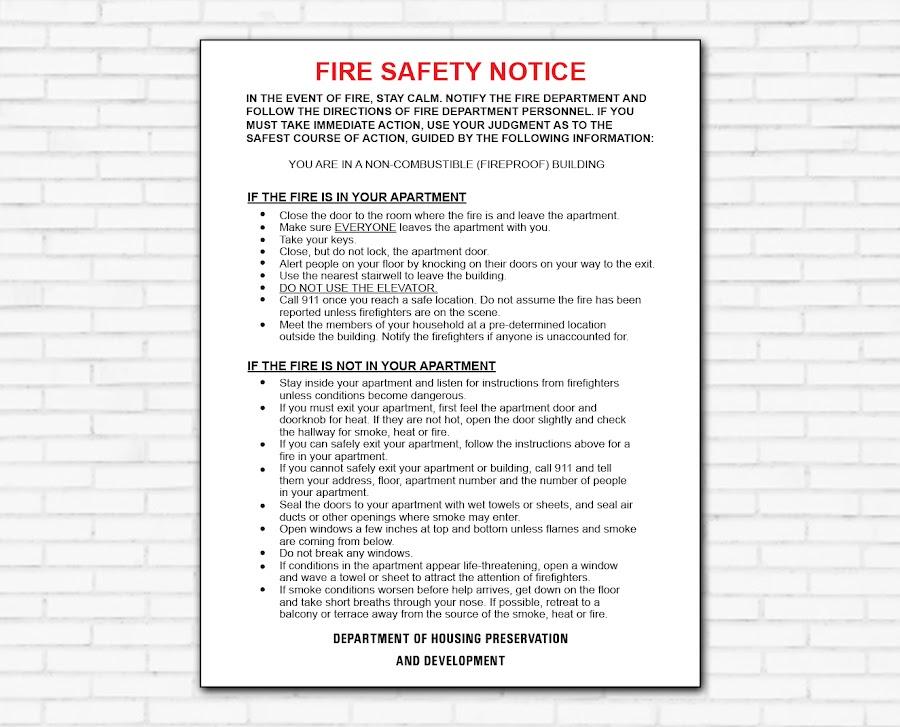 Fire Safety Notice mounted on a white brick wall