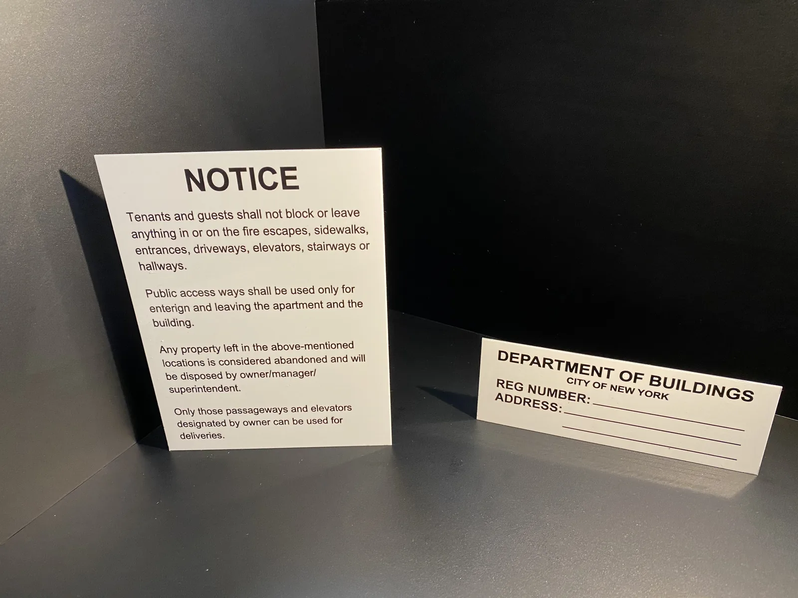 White aluminum HPD notice and Department of Buildings registration number sign